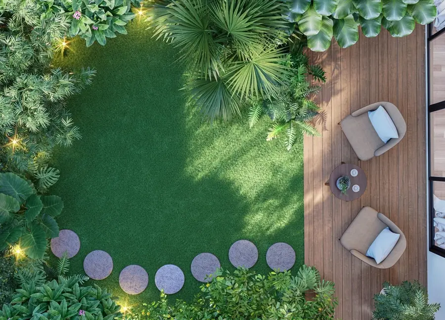 Backyard from above with turf, round stepping stones, plants and a wood deck