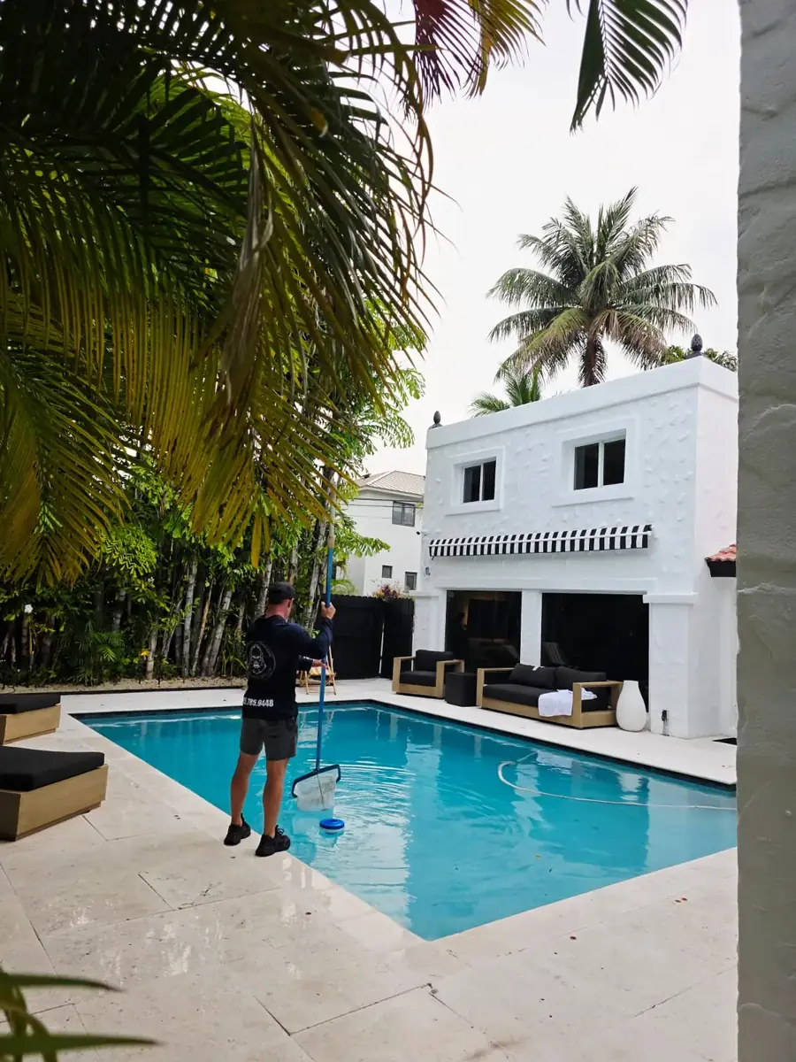 Rectangular pool with a stone patio, lawn and lanterns